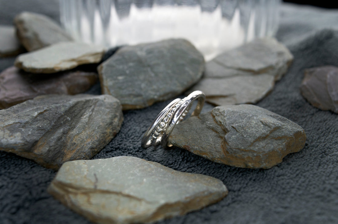 Trio of sterling silver rings by Dela Comeco, showcasing different designs and finishes, handcrafted in Bridgend, South Wales.