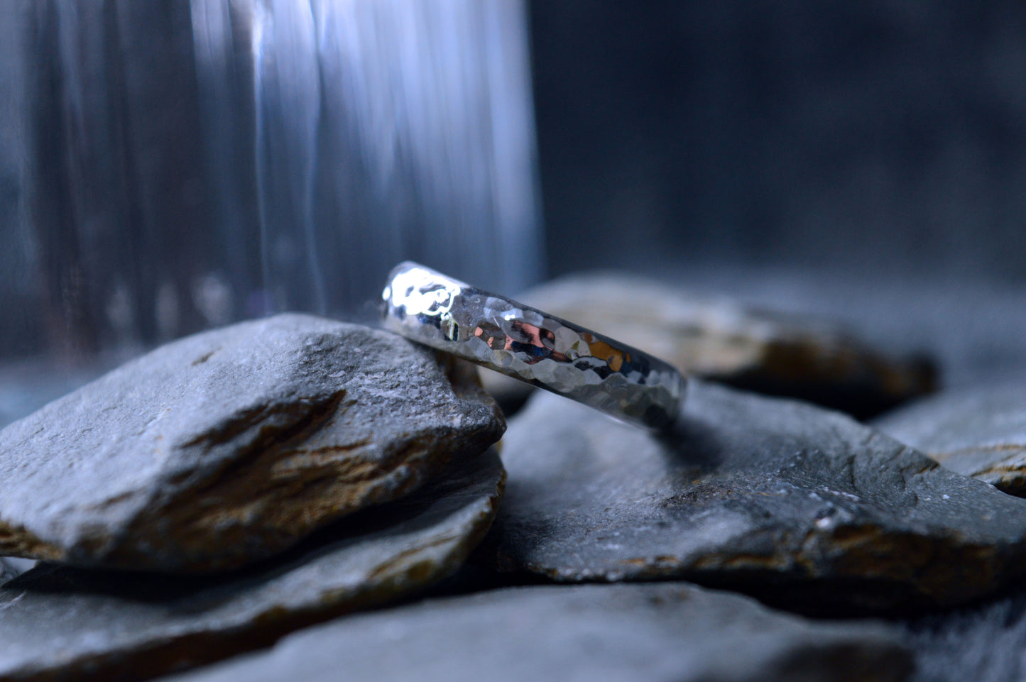 A shiny 925 sterling silver ring with a textured surface and 5mm x 2mm dimensions. The handmade ring displays a unique, handcrafted quality.