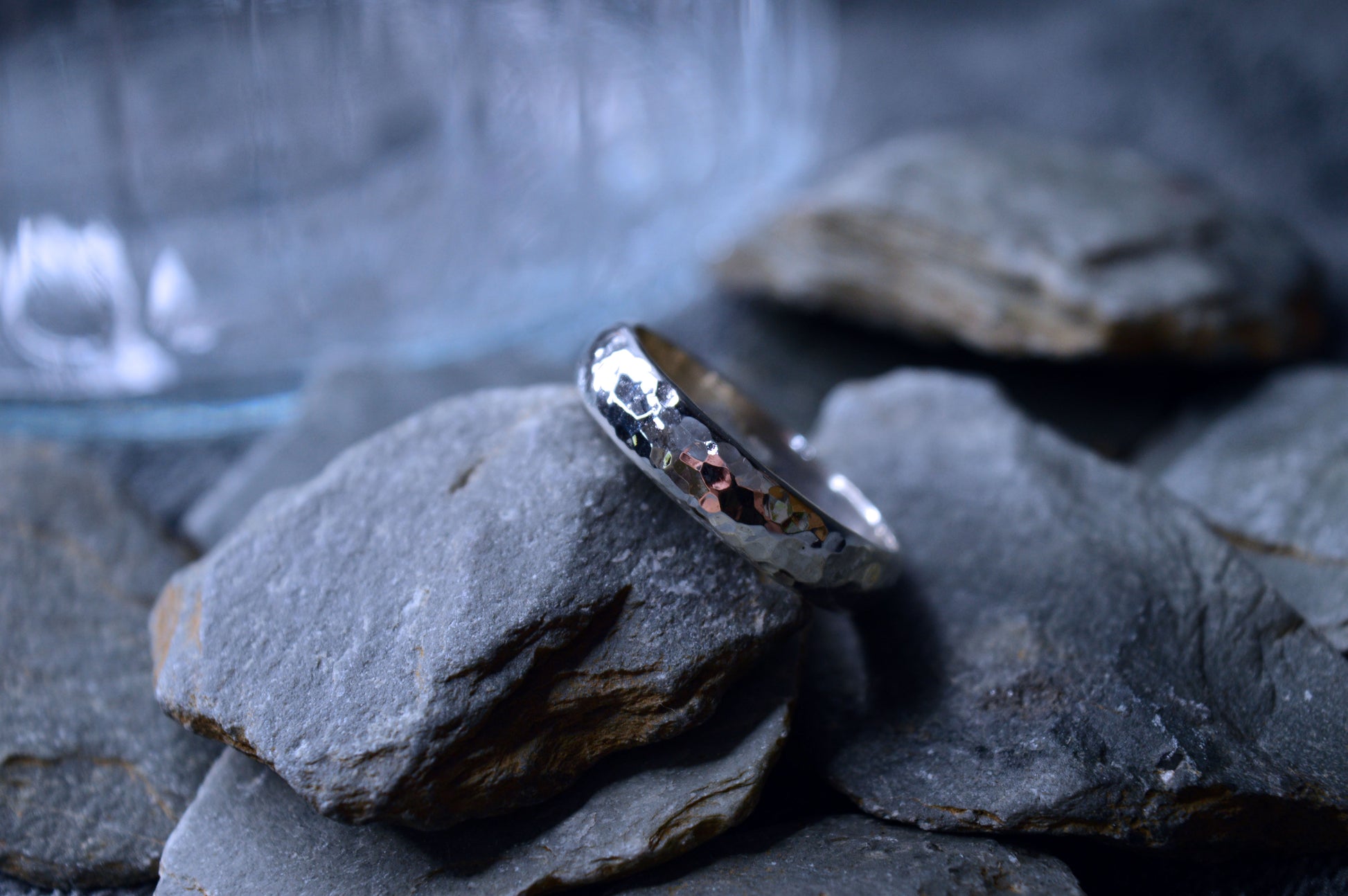 A silver ring with a distinctive hammered pattern, made from 925 sterling silver. The 5mm wide and 2mm thick band is handmade and unique.