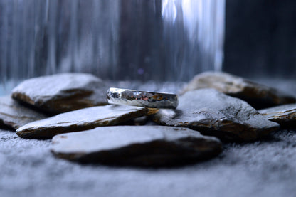 Detailed view of a hammered sterling silver ring, 5mm wide and 2mm thick. The ring is handmade to order, giving each one a one-of-a-kind look.