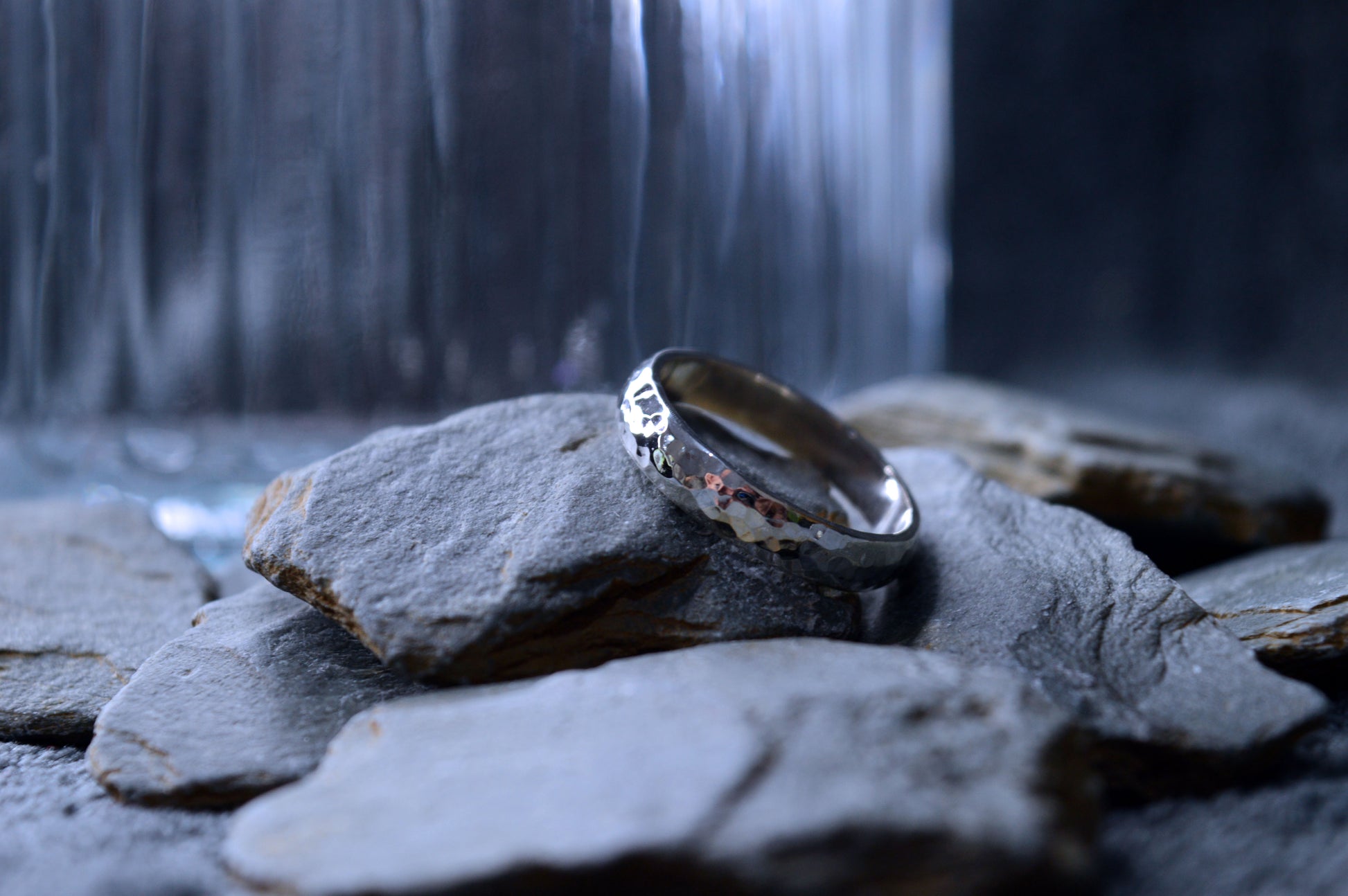 Side view of medium-width 4 x 2mm hammered silver ring, reflecting light beautifully.