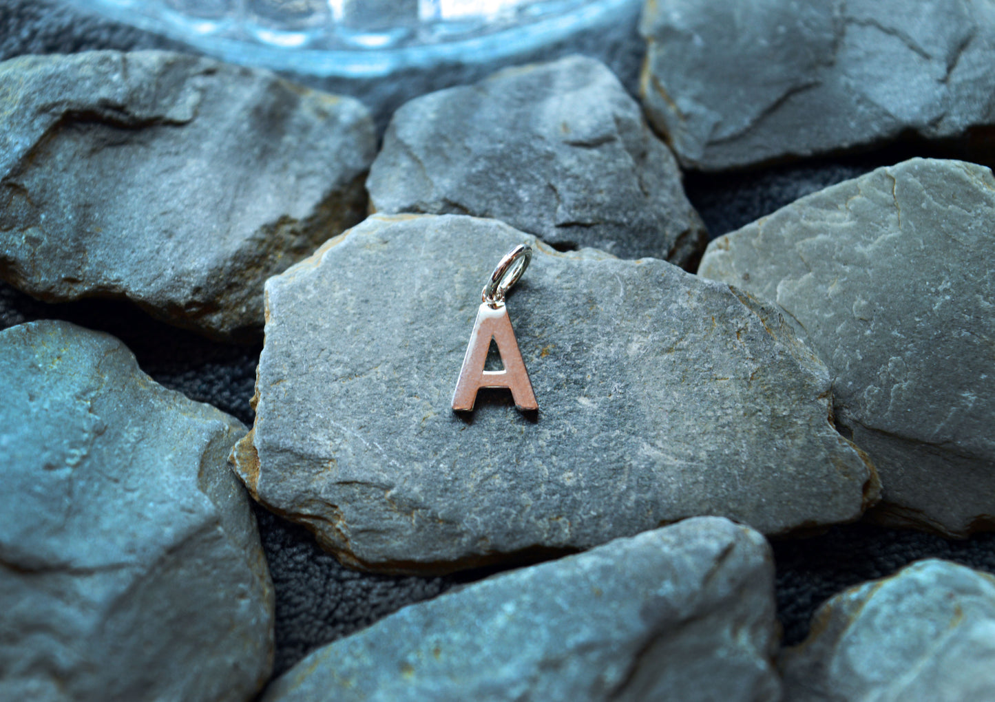 A sterling silver initial pendant with a pre-looped design, featuring a 3.5mm hole for small necklaces up to 3mm thick.