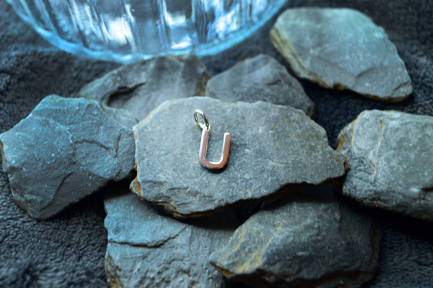 A sterling silver pendant shaped like an initial, featuring a 3.5mm internal loop and designed for small necklaces.