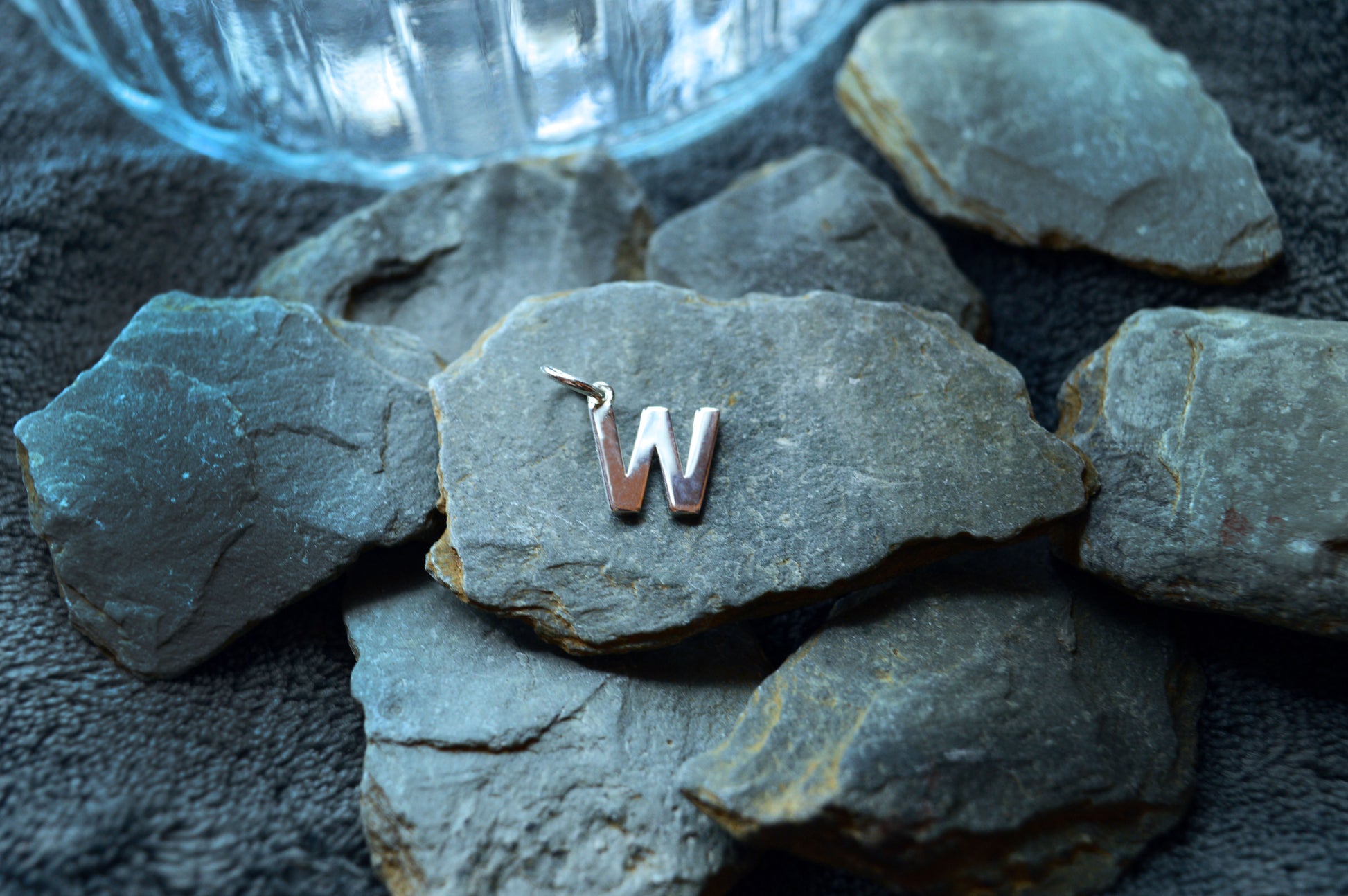 Handcrafted sterling silver letter pendant, 10mm tall and 8mm wide, with a loop designed to fit 3mm thick chains.