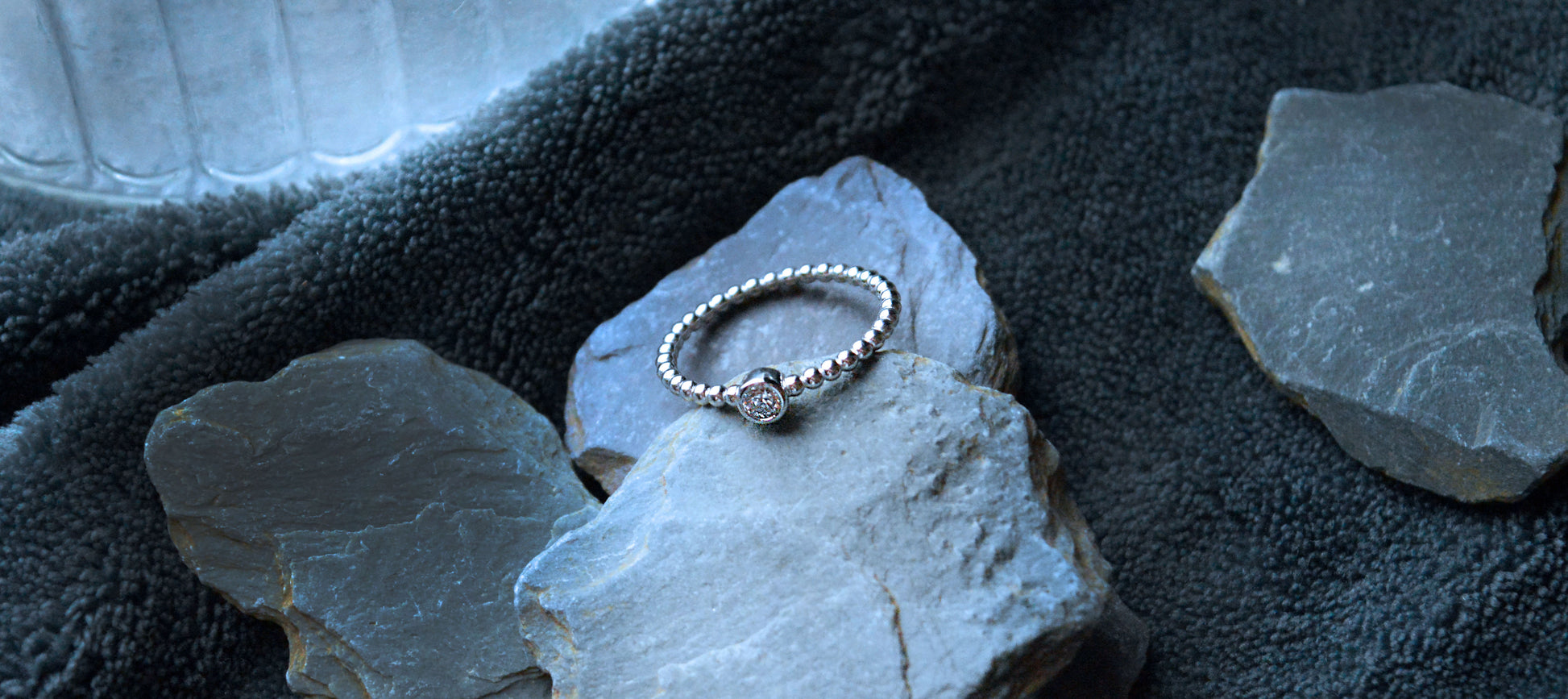 Close-up of a 925 sterling silver beaded band ring featuring a 4mm CZ gemstone. The minimalist 2mm band offers a simple yet elegant design.