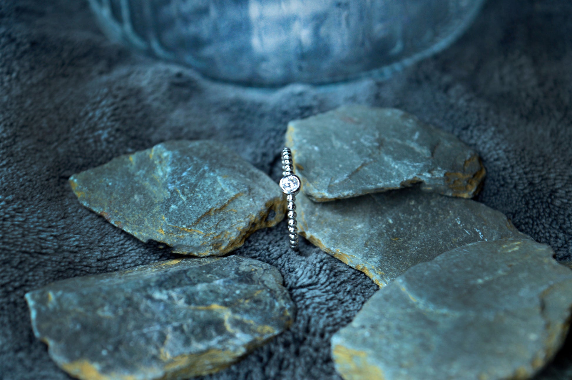 Detailed view of a dainty 925 sterling silver beaded band ring with a 4mm cubic zirconia gemstone. The 2mm wide band highlights a refined, minimalist style.