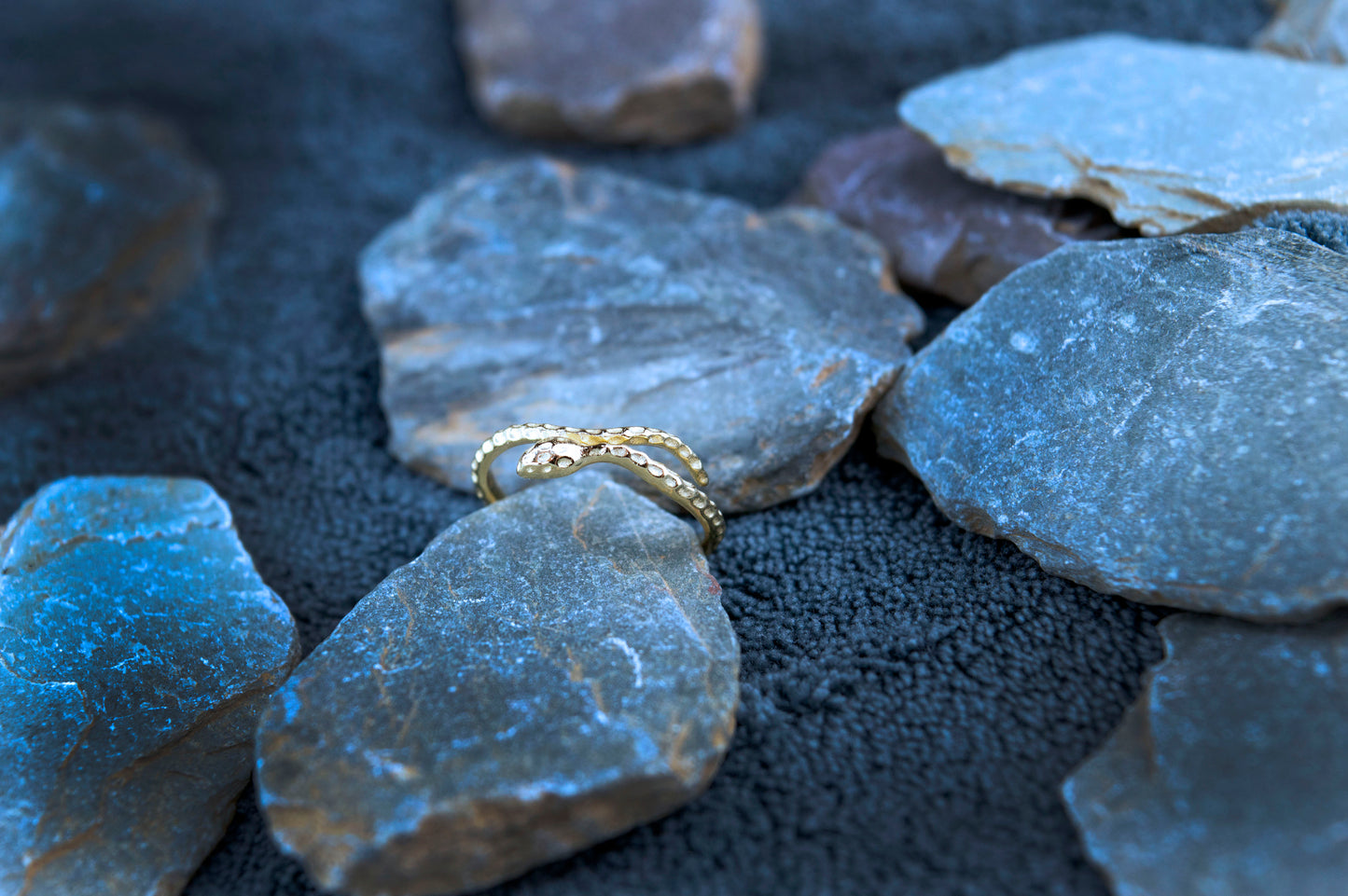 Sophisticated 14ct gold-plated snake ring on a display, featuring a 1.5mm band width and an adjustable fit. The ring’s elegant snake design embodies modern luxury.